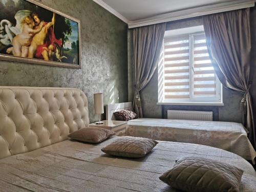 切尔尼戈夫切尔尼戈夫市中心公寓的一间卧室设有两张床,墙上挂着一幅画