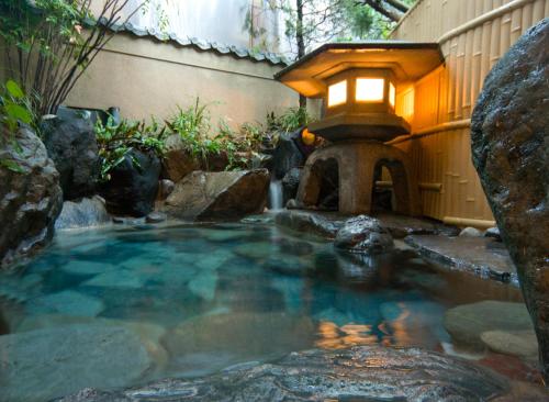 下吕市伊祖梅索酒店的一个小水池,有灯笼和一个喷泉