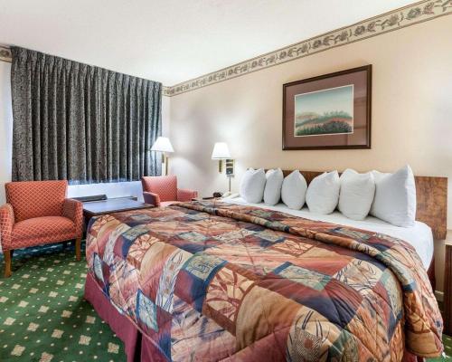 Jasper贾斯珀罗德威汽车旅馆的酒店客房带一张大床和椅子