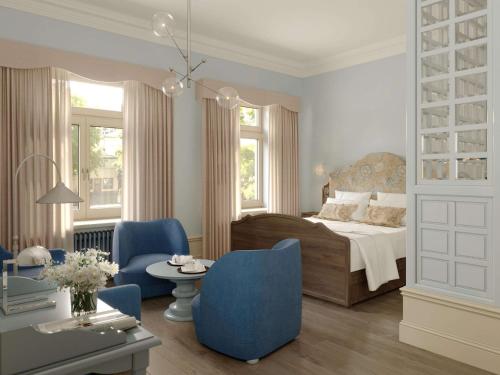 斯德哥尔摩Hotel Ruth, WorldHotels Crafted的一间卧室配有一张床和两张蓝色椅子
