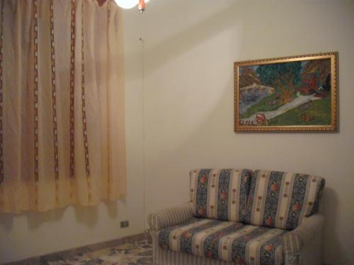 卡拉塔菲米Calatafimi Segesta - Appartamento Garibaldi的客厅配有椅子和墙上的绘画