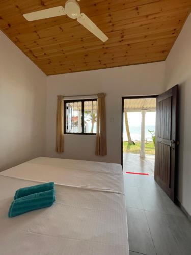 高尔Saman Beach Guest House的卧室配有一张大白色床和窗户