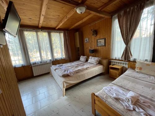瑟尔尼察Вила Мерджан的一间卧室设有两张床、一台电视和窗户。