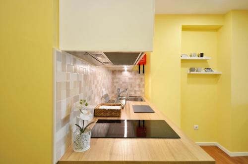 布拉加RH Charming Apartment Liberdade II的厨房设有水槽和黄色的墙壁