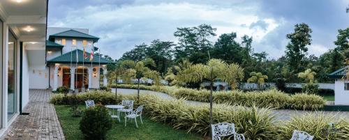 马特莱Lakegala Resort的享有带白色椅子和桌子的花园美景。