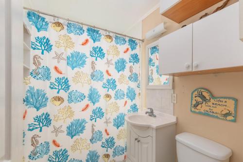 泰比岛Palmwood Paradise的浴室设有蓝色和白色的淋浴帘