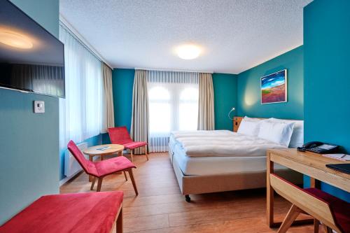 因特拉肯5th Floor Basic Rooms - shared bathrooms的酒店客房带一张床、一张桌子和椅子