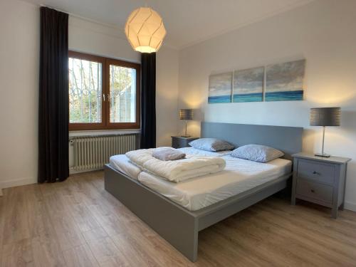 施莱登Villa Holgenbach - Penthouse- und Ferienwohnung im Nationalpark Eifel的一间卧室设有一张大床和一个窗户。