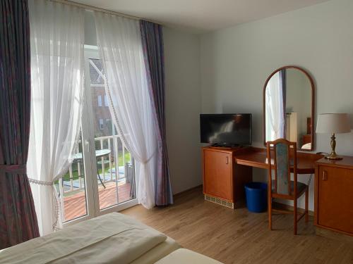 赫茨拉克弗洛拉酒店的一间卧室配有一张床、一张书桌和一个窗户。