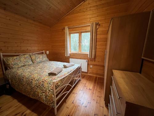 南塞尔尼Kingfisher Lodge, Lake Pochard的小木屋内一间卧室,配有一张床