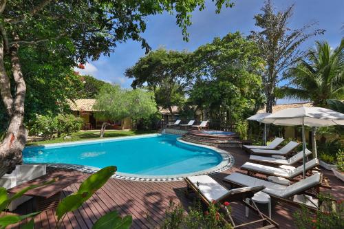 皮帕巴西热带村酒店的一个带躺椅和遮阳伞的游泳池