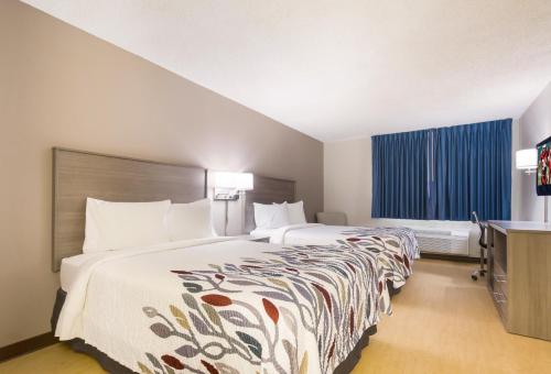 劳伦斯堡Red Roof Inn Lawrenceburg的酒店客房设有两张床和电视。
