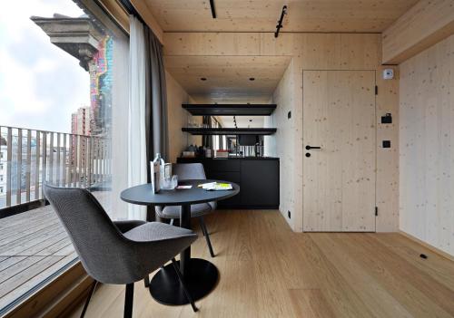 维也纳numa l Wood Rooms & Apartments的一间小餐厅,配有桌子和大窗户