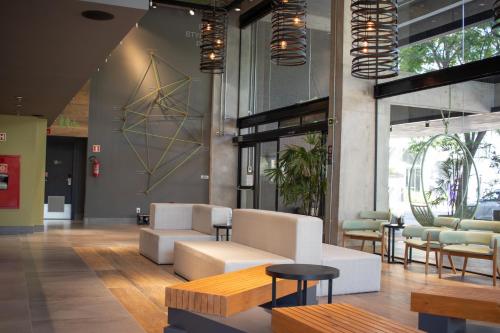 阿雷格里港ibis Styles Porto Alegre Moinhos de Vento的大厅,在大楼里设有沙发和桌子