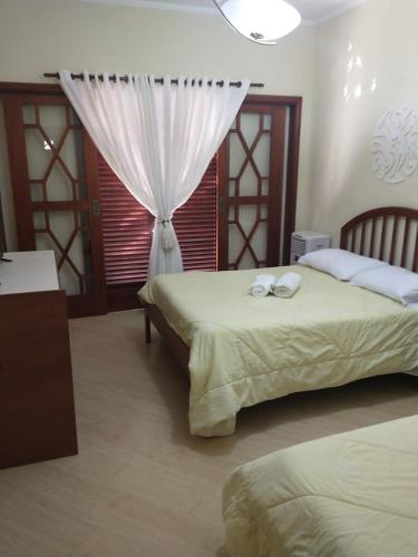 塞拉内格拉Casarão Primavera的一间卧室设有两张床和窗户。