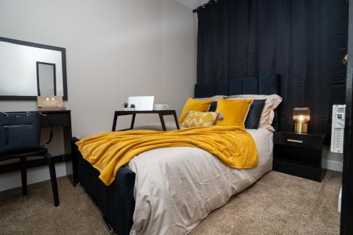 曼彻斯特JPG Tower Suite - 22nd Floor Canal & City Views的一间卧室配有一张黄色毯子床