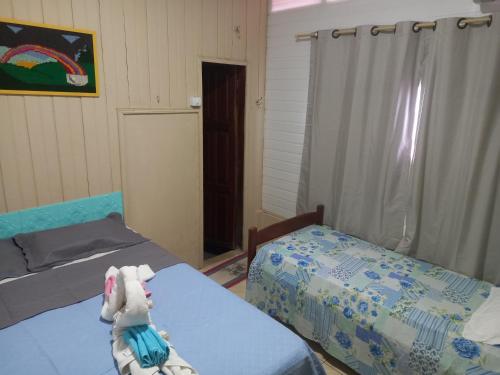 阿尔特杜尚Pousada Recanto da Mada Alter的卧室配有两张床,床上放着一只动物。