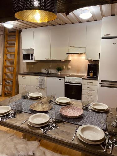鲁卡Ruka Chalet Roma的厨房配有带盘子和盘子的桌子