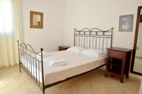 特里皮蒂Trypiti Sea View Apartment的一间卧室配有一张床、一个木制床头柜和一张四柱床
