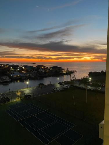 哈得逊Cozy Gulf of Mexico Resort Condo #603 in Hudson的日落时在海洋前的网球场