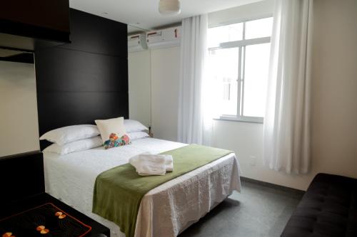 里约热内卢Ipanema 309 Studio的一间卧室配有一张带绿毯的床和窗户。