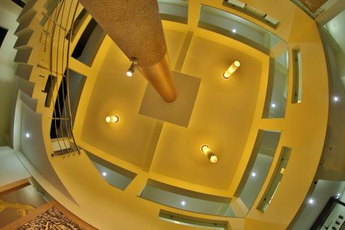 KālapettaiHOTEL PRISO的黄色天花板的建筑中的螺旋楼梯