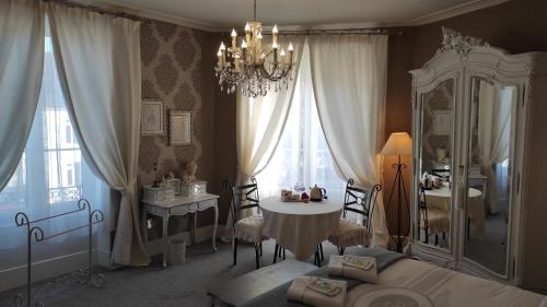 Beauchamps乐谱号多特住宿加早餐旅馆的一间卧室配有一张床、一张桌子和一个吊灯。