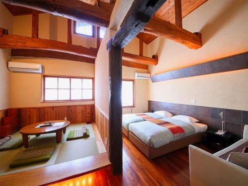 白马村Kunugi Relaxation with 4 modern rooms的一间卧室配有一张床、一张桌子和一张桌子