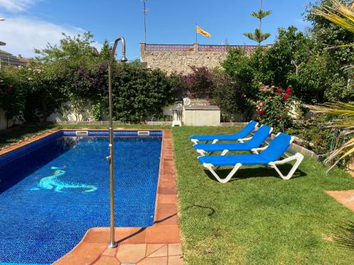 克尤伯厄拉斯Villa Dacar的游泳池旁设有2把蓝色躺椅
