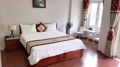 Bồ SơnGALAXY HOTEL Bắc Ninh的一间卧室配有一张床、一张桌子和一个窗户。