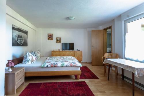 文迪施里茨Bungalow am Wassergrundstück的一间卧室配有一张床、一张桌子和一台电视