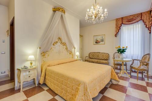 威尼斯马尔特酒店的卧室配有一张床和一张桌子及椅子