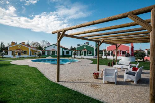 Vale de SantarémQR Casas de Campo的庭院设有木制凉亭,毗邻游泳池