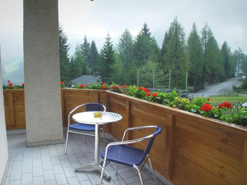 索内纳尔佩·纳斯费尔德Apartment in Hermagor Pressegger See with sauna的阳台的天井配有2把椅子和1张桌子