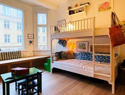 哥本哈根ApartmentInCopenhagen Apartment 1282的配有一张桌子和一张桌子的客房内的双层床
