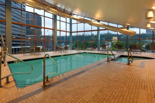 匹兹堡匹兹堡温德姆大酒店的一座大型游泳池,位于一座带窗户的建筑内