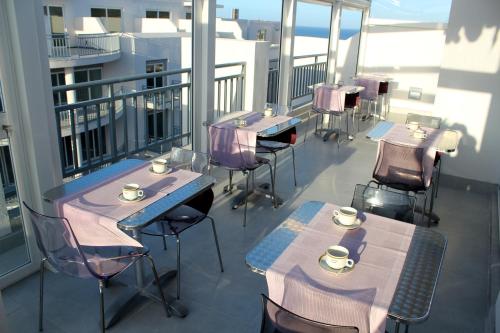 马萨尔福恩Atlantis Lodge的阳台配有桌椅和杯子