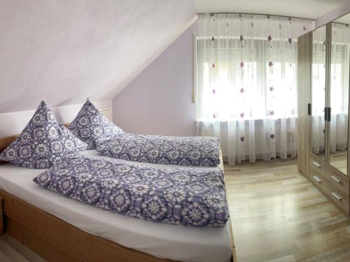 朗根阿根Ferienwohnung bei Fredy的一间卧室配有一张带蓝色枕头的床。