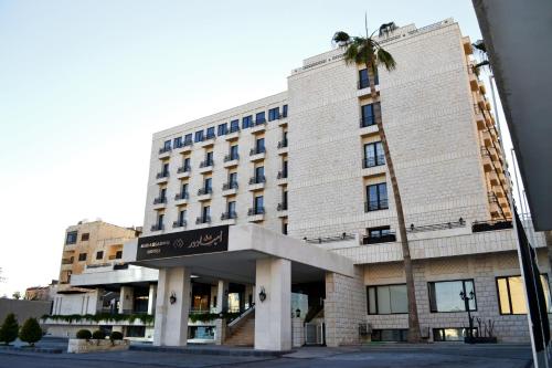 安曼Ambassador, a Boutique Hotel的前面有棕榈树的建筑