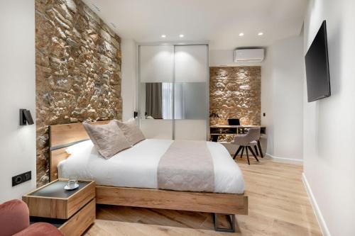 雅典J&A Luxury Residence的一间卧室设有一张床和石墙
