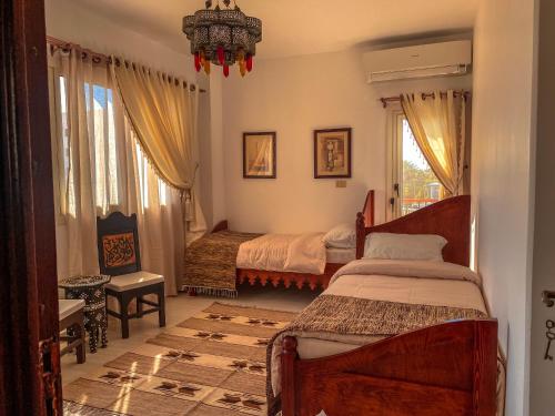 赫尔格达Royal Suite on The Touristic Promenade的一间卧室配有两张床和吊灯。