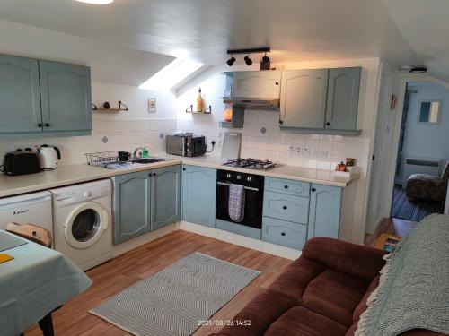 斯特罗姆内斯Stromness Apartments的厨房配有蓝色橱柜和炉灶烤箱。
