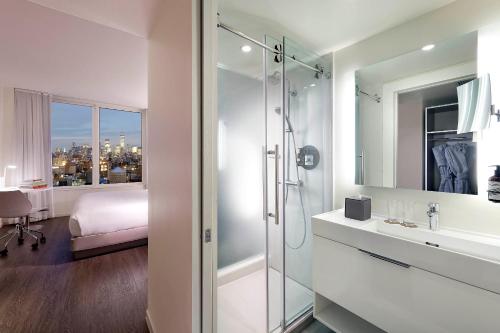 纽约INNSiDE by Meliá New York Nomad的带淋浴和盥洗盆的浴室以及1张床。