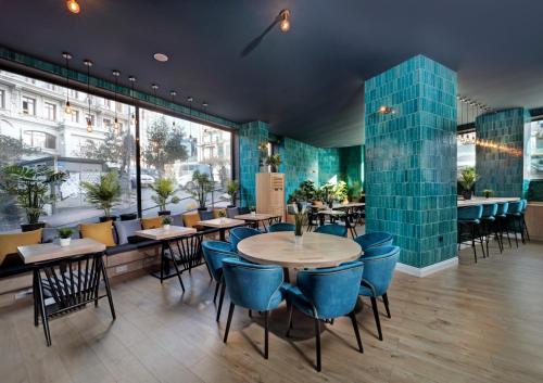 伊斯坦布尔The Central House Istanbul Galata的餐厅设有桌椅和大窗户。