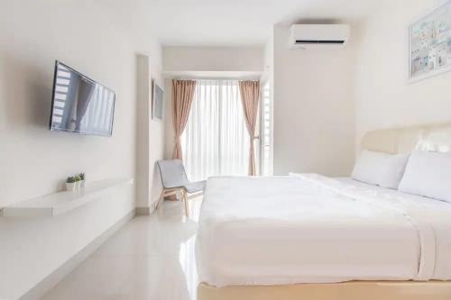 贝克西RedLiving Apartemen Grand Kamala Lagoon - Kita Pro Tower Barclay North的白色的卧室设有一张大床和一个窗户