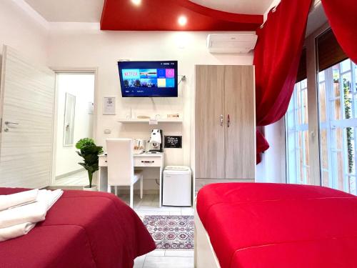 那不勒斯Terrazza Garibaldi的一间卧室配有红色的床和一张书桌