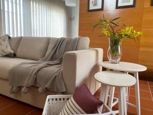 卡帕里卡海岸TOP BEACH HOUSE的客厅配有沙发和花瓶(桌子上)