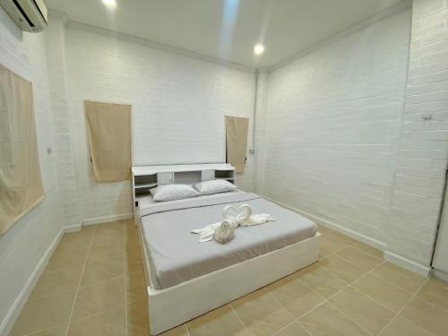 Ban Sa LaWhitehouse cafe&Guesthouse的一间卧室配有一张带白色毛巾的床