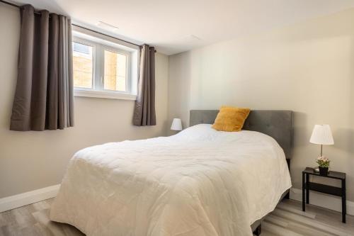 基奇纳ENTIRE 2 BEDROOM APARTMENT DOWNTOWN - u1的一间卧室配有一张黄色枕头的床