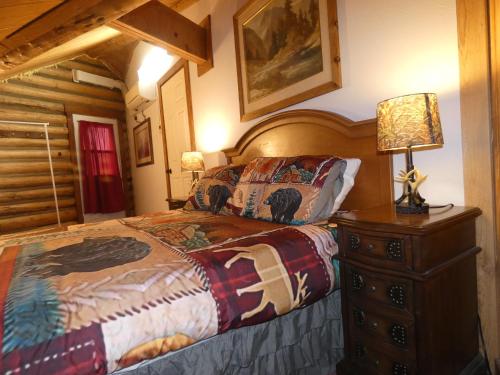 西黄石Yellowstone Motel - Adults Only - All rooms have kitchens的一间卧室配有一张床,梳妆台上配有一盏灯